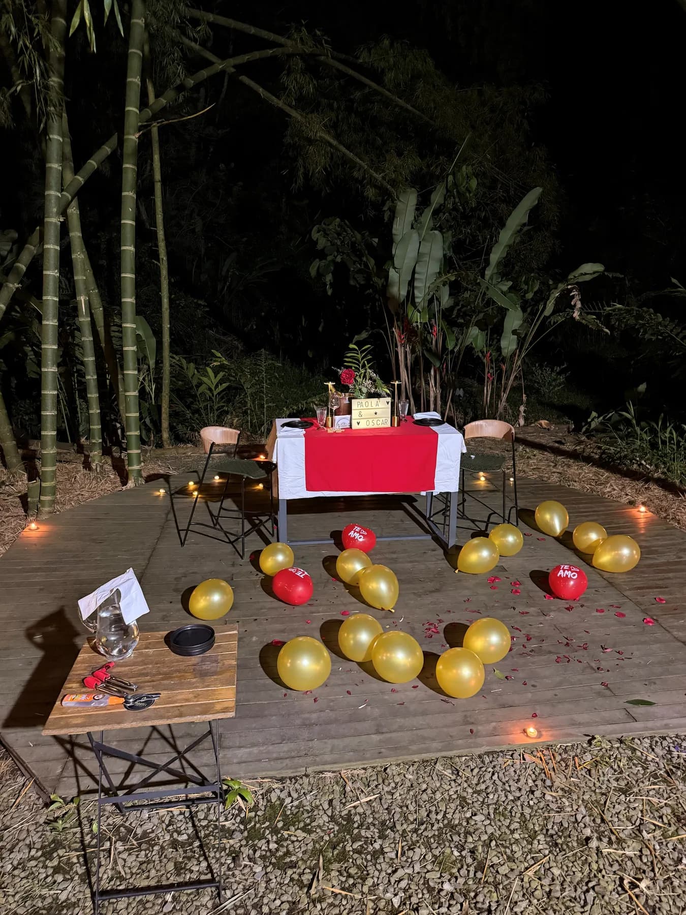 Table set with candles and balloons in the bamboo grove at dusk