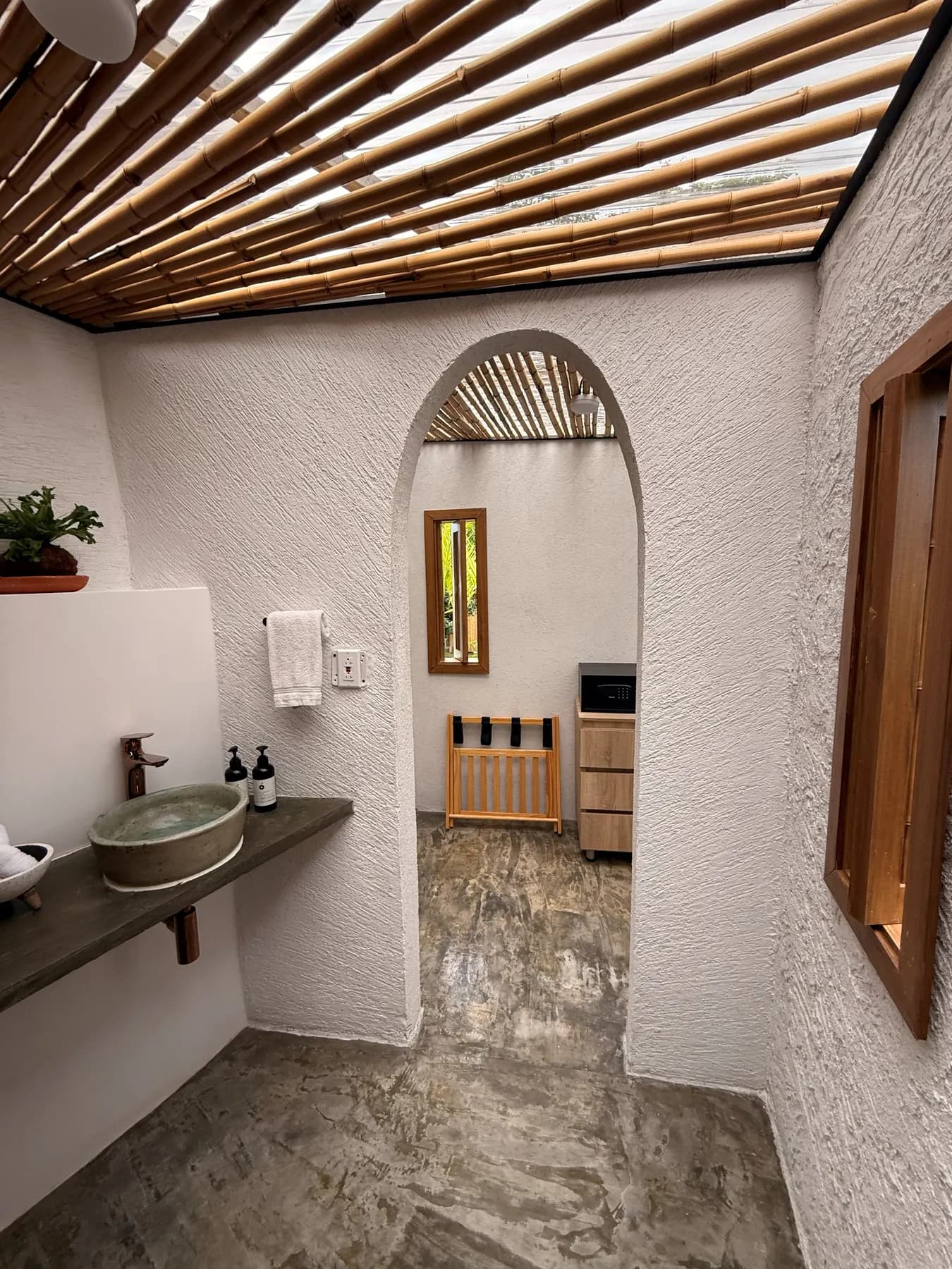 The dome’s bathroom with a stone basin, an arched mirror and a bamboo ceiling