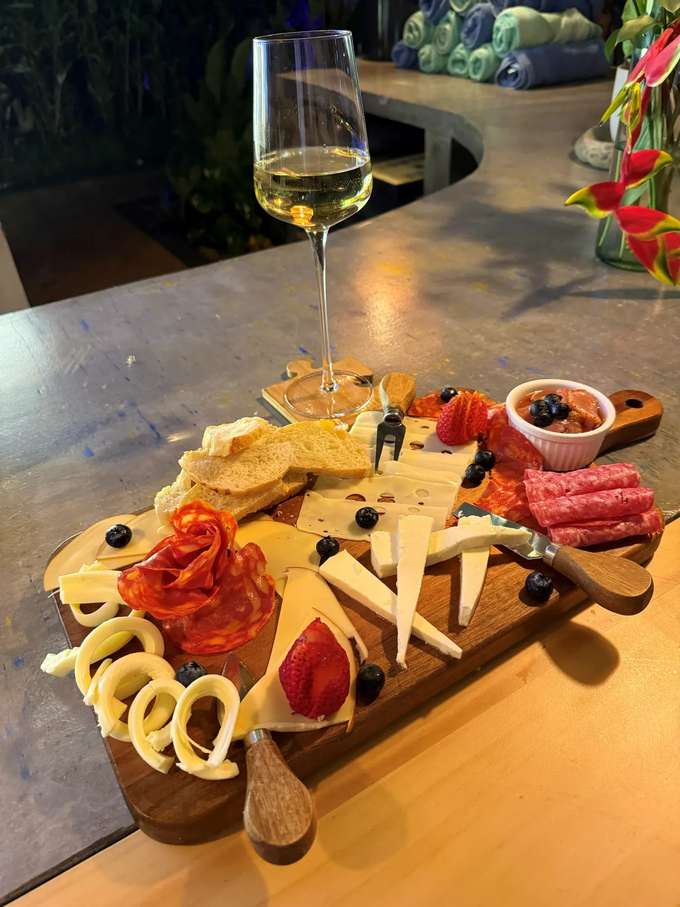Cheese and charcuterie board with a glass of wine on a wooden table