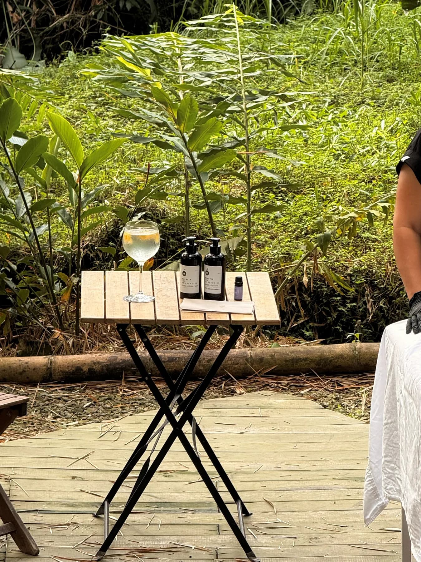 Massage table on a wooden deck with a tray of oils in front