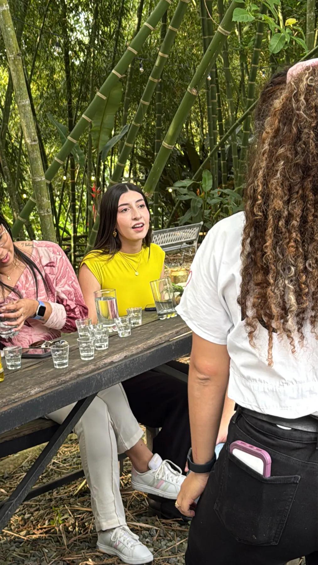 Friends around a long wooden table in the bamboo grove