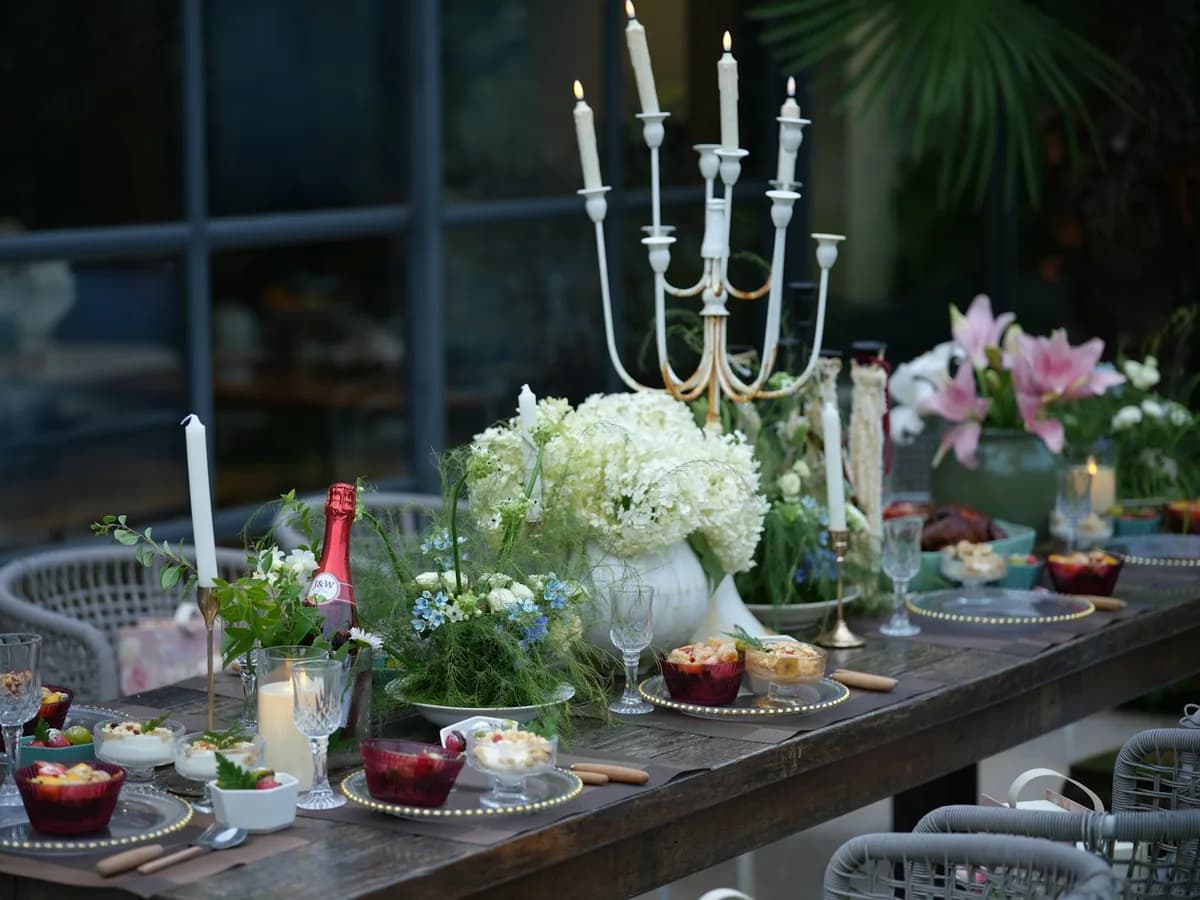An outdoor table with a candelabra and flowers