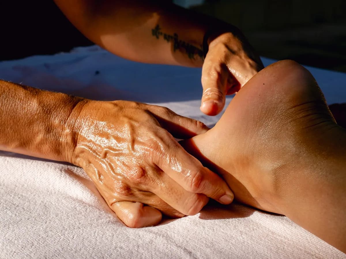 A therapist’s hands massaging a foot