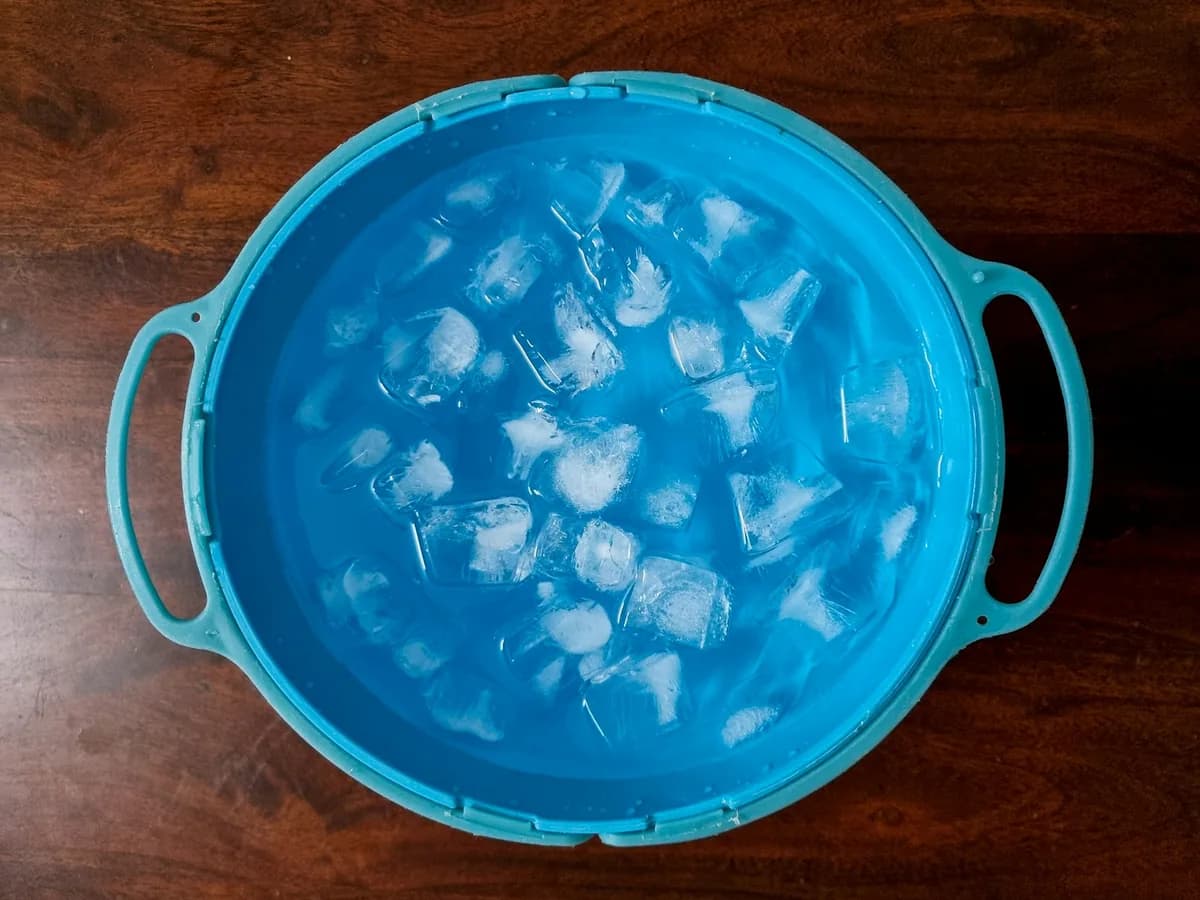A blue tub full of ice cubes, seen from above