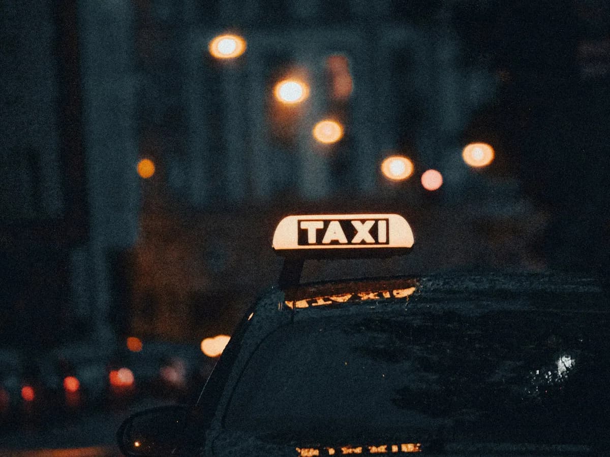 A lit taxi sign at night