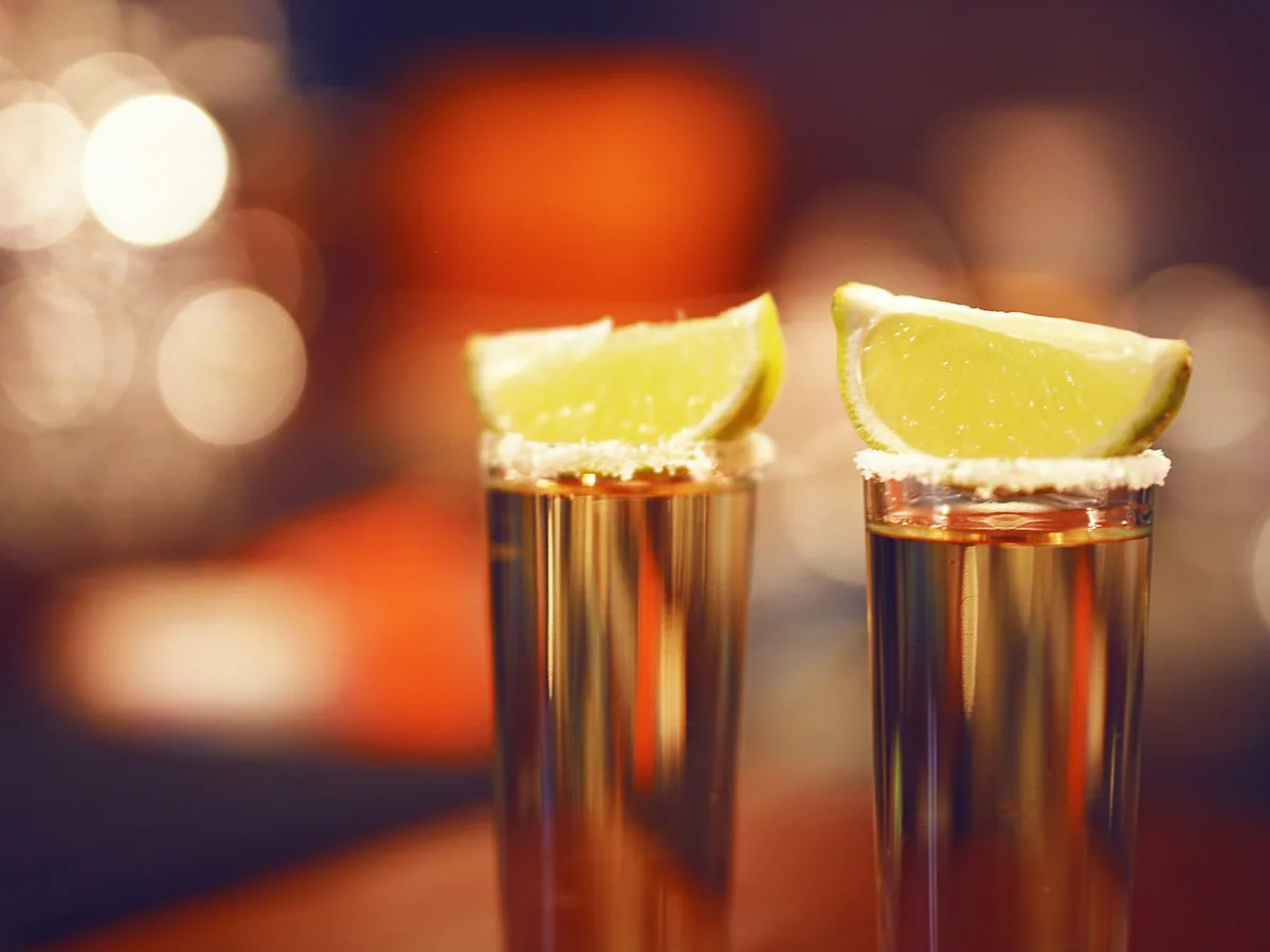 Two tequila shots with lime slices