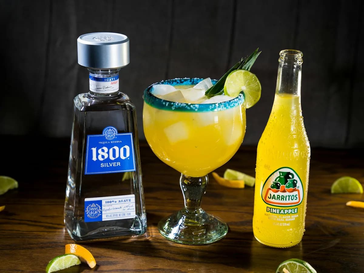 A bottle of 1800 Silver tequila with a margarita