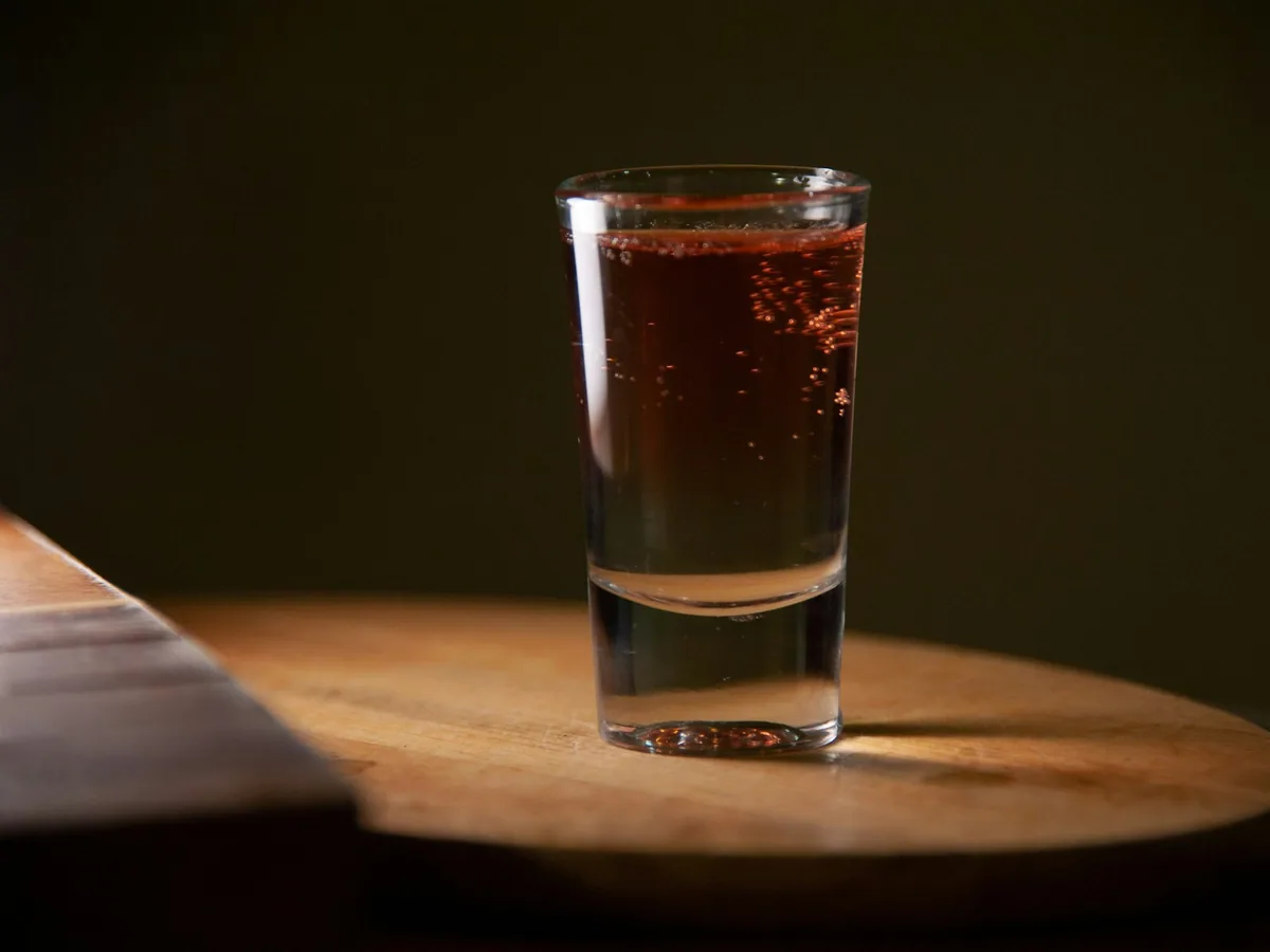 A shot in a tall glass on wood