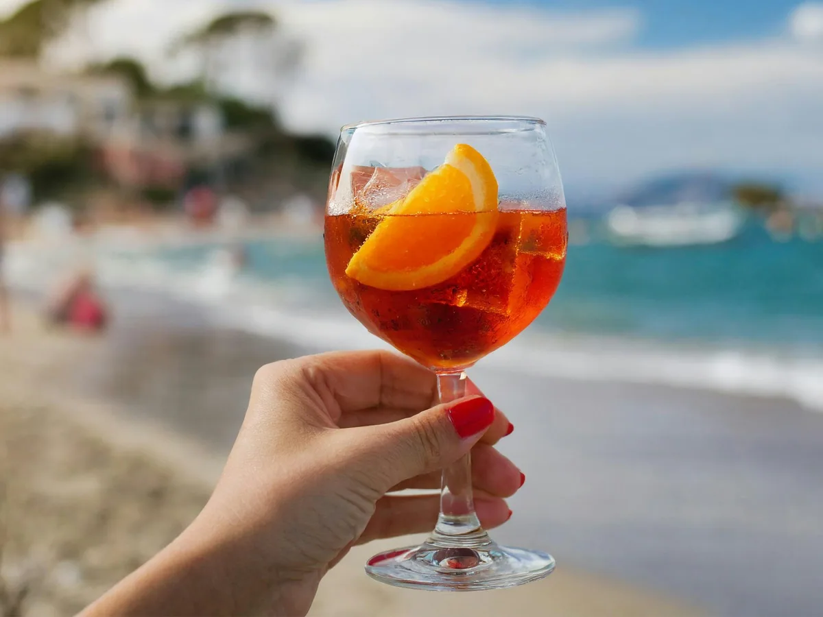An Aperol spritz with orange by the sea