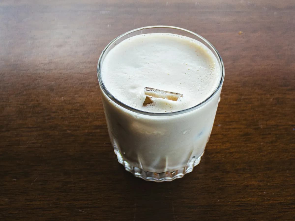 A glass of cream liqueur beside a tray of sweets