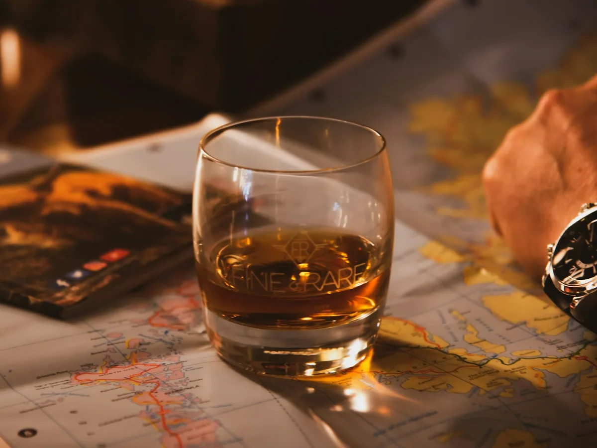 A glass of whisky on a wooden bar