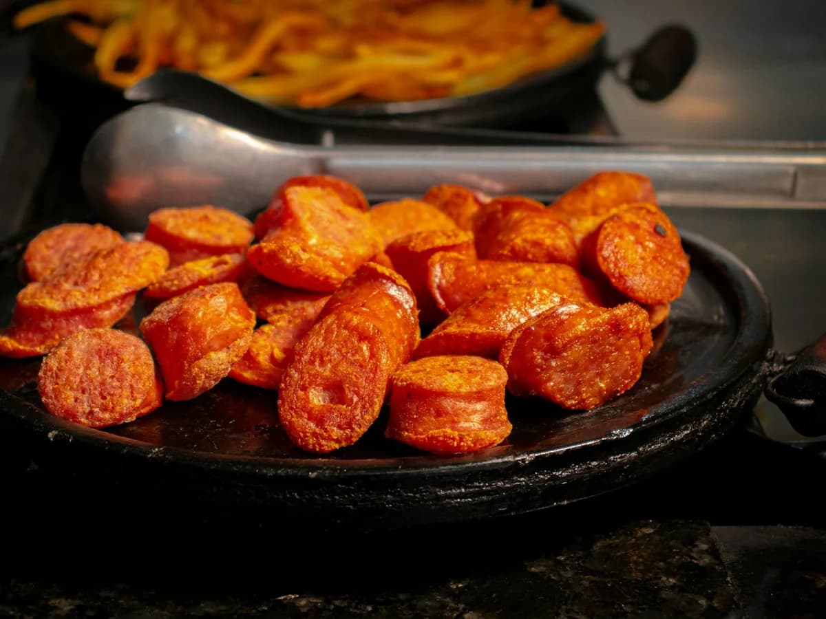 Golden chorizo slices in a pan