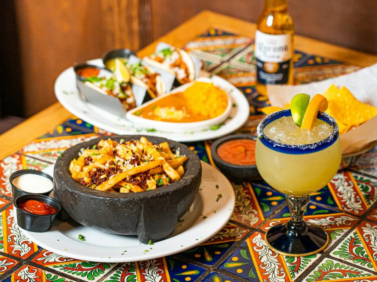 Tacos and a margarita on a colourful tablecloth