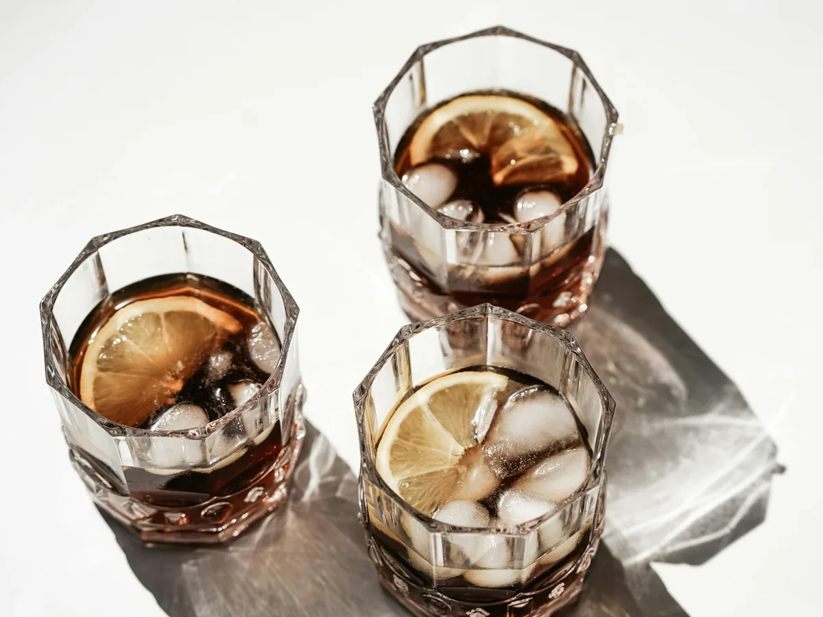 Two glasses of cola cocktail with ice, seen from above