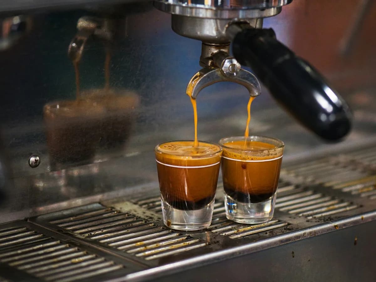 Espresso pouring into two glasses from the machine