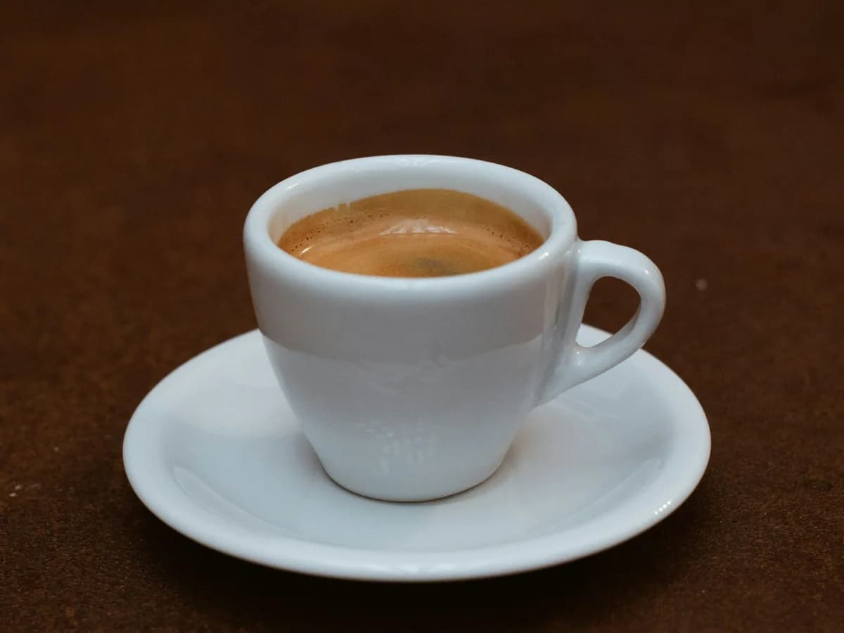 An espresso cup and saucer against a white ground