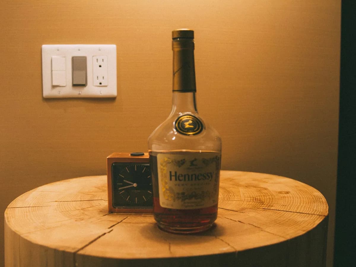 A bottle of Hennessy on a wooden table