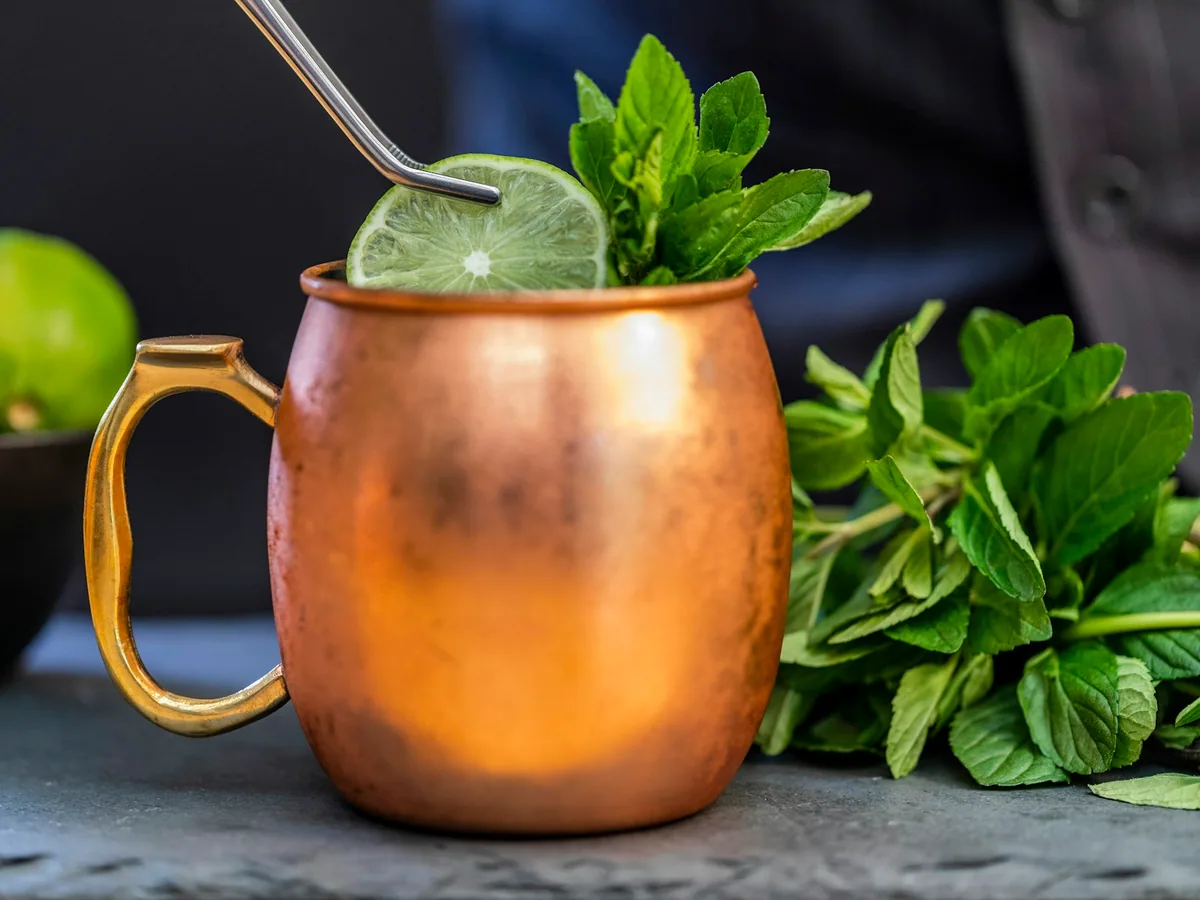 A Moscow mule in a copper mug with mint and lime