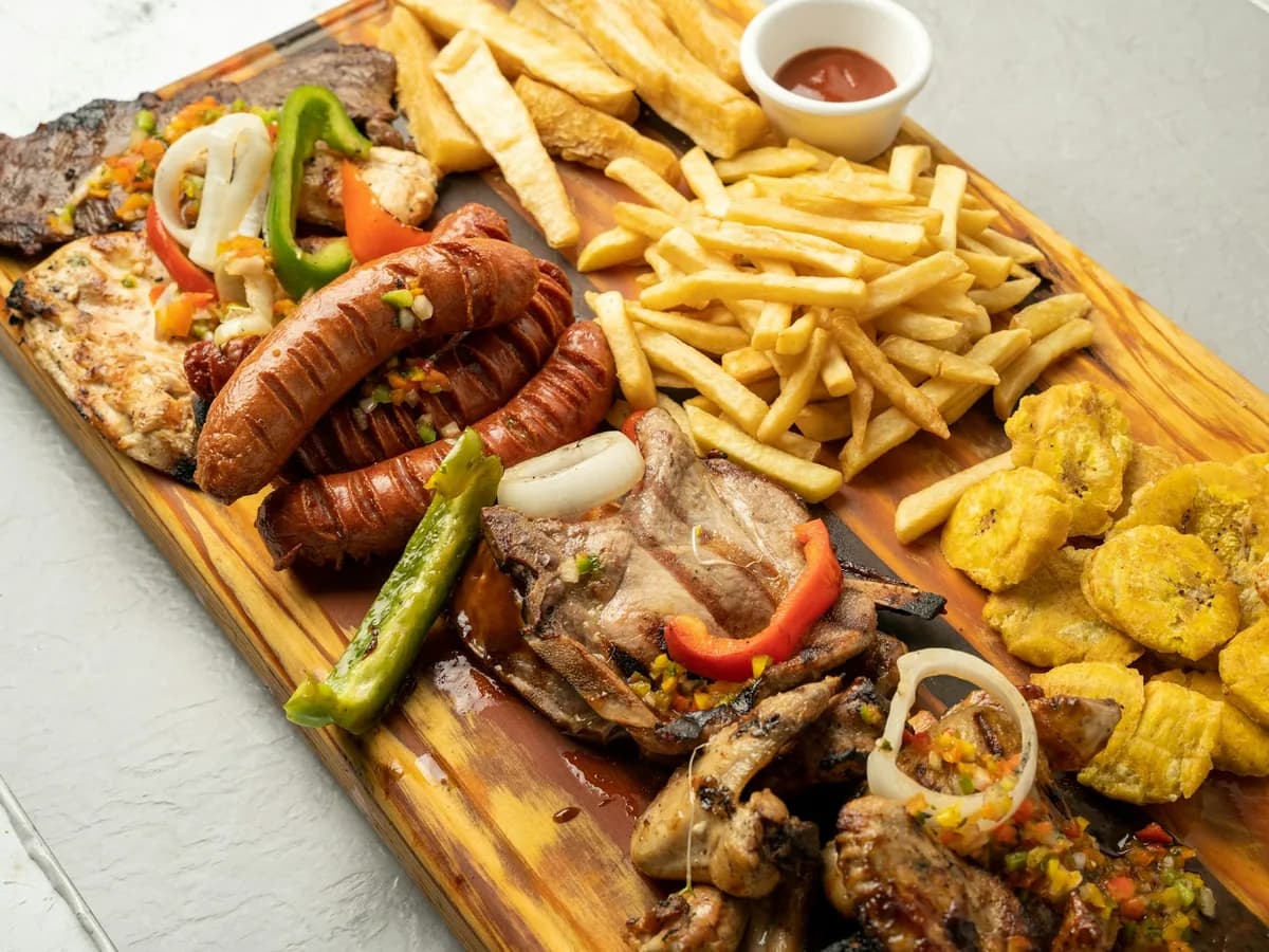 A picada board with meats, fried potatoes and patacones