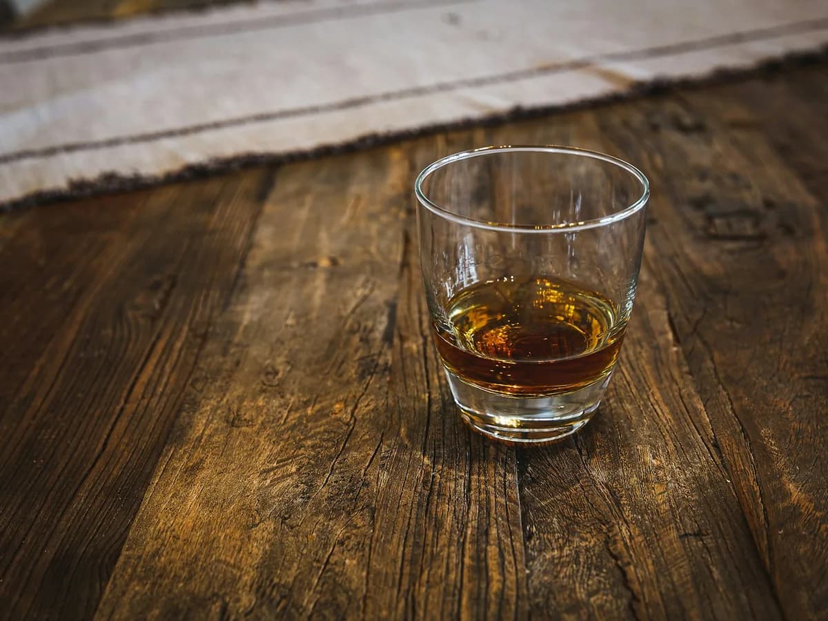 A glass of rum on a wooden table