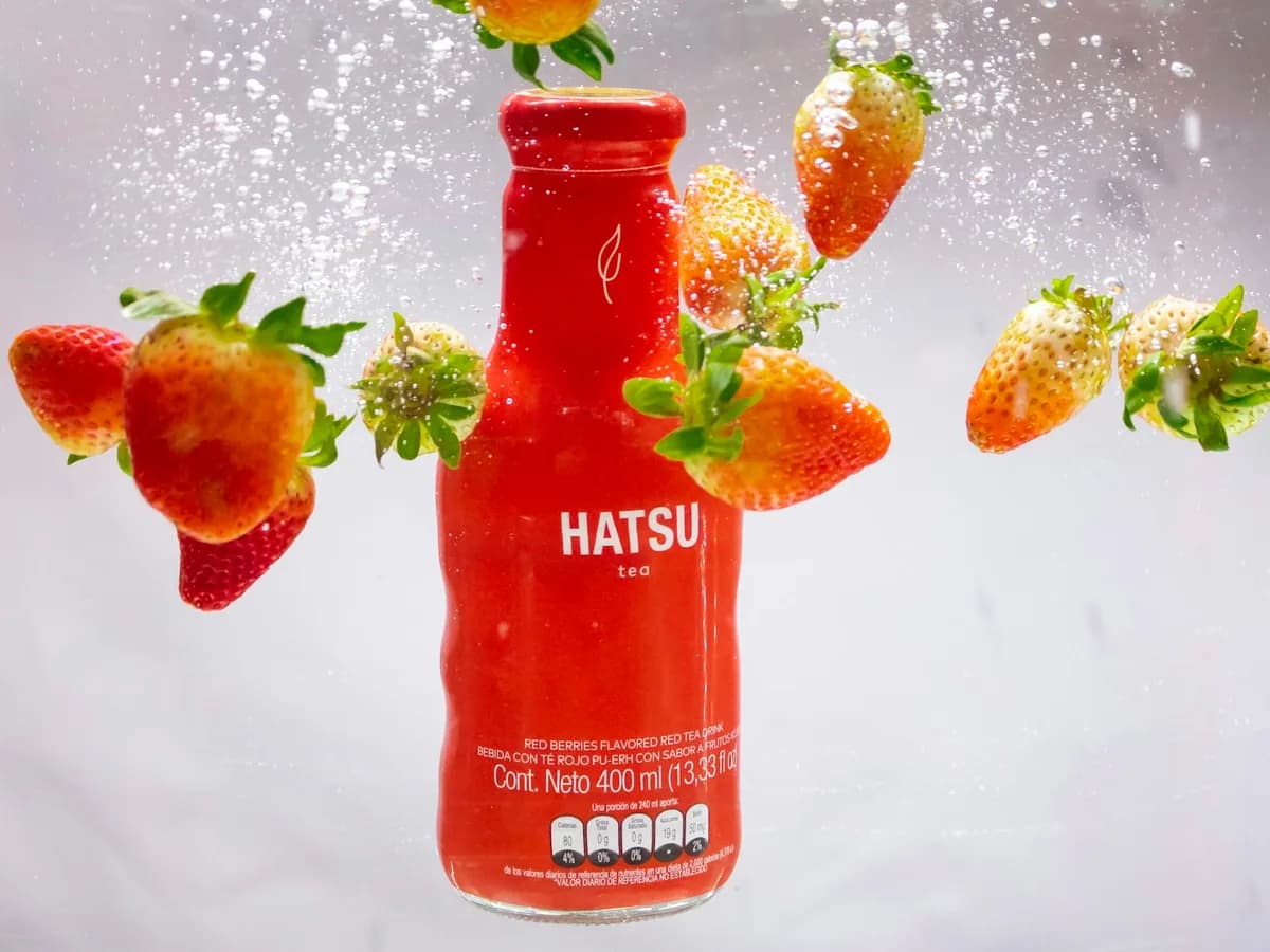 A bottle of Hatsu soda with strawberries and a splash
