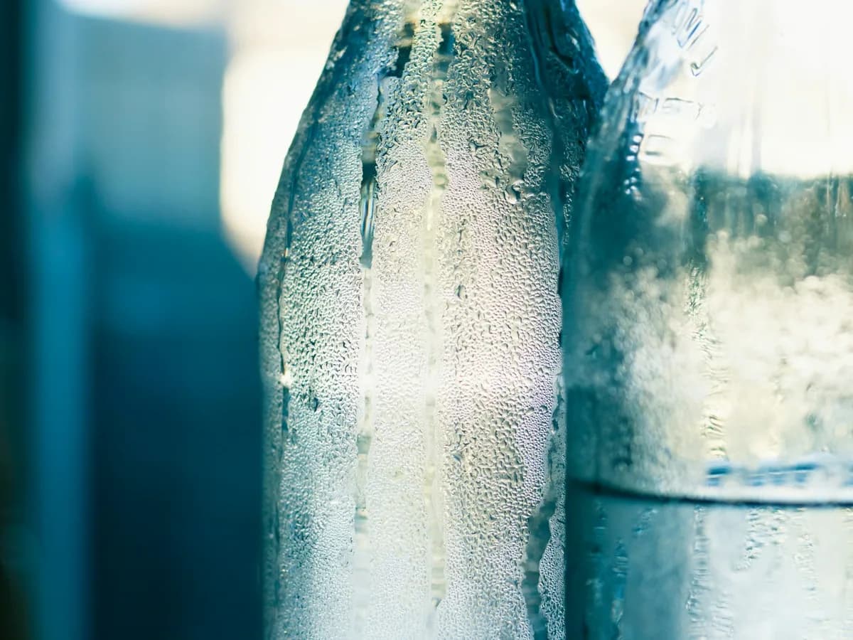 A bottle of soda water beaded with condensation