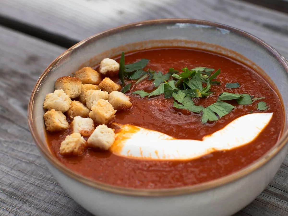 Tomato soup with croutons, basil and a swirl of cream