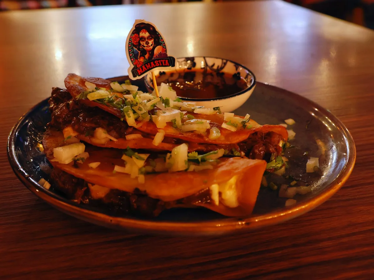 Golden birria tacos with onion on a plate