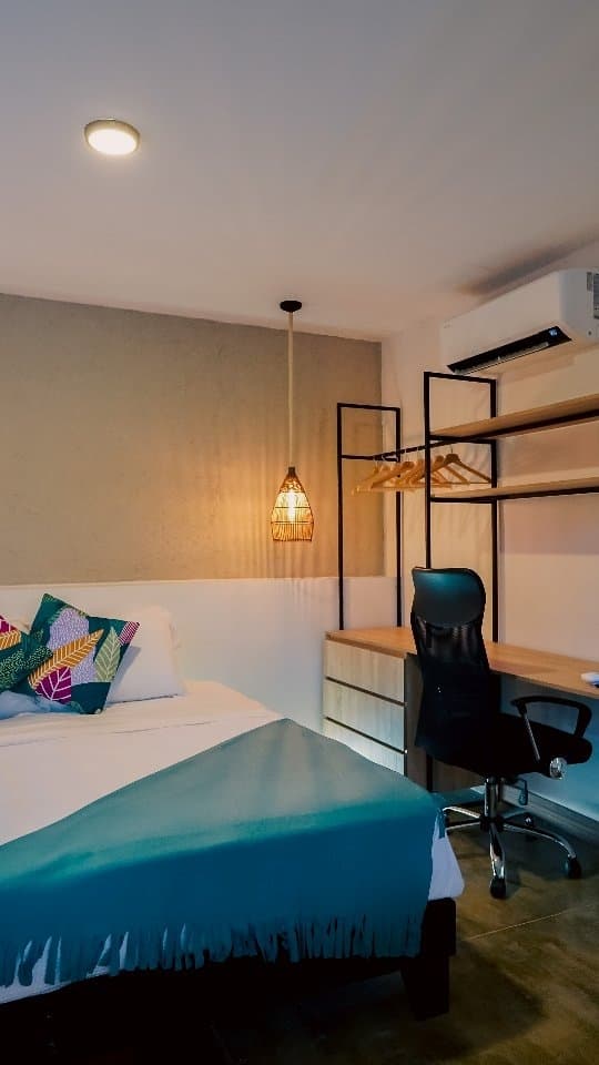 The Colombiana Alta room with its bed, desk and iron clothes rail