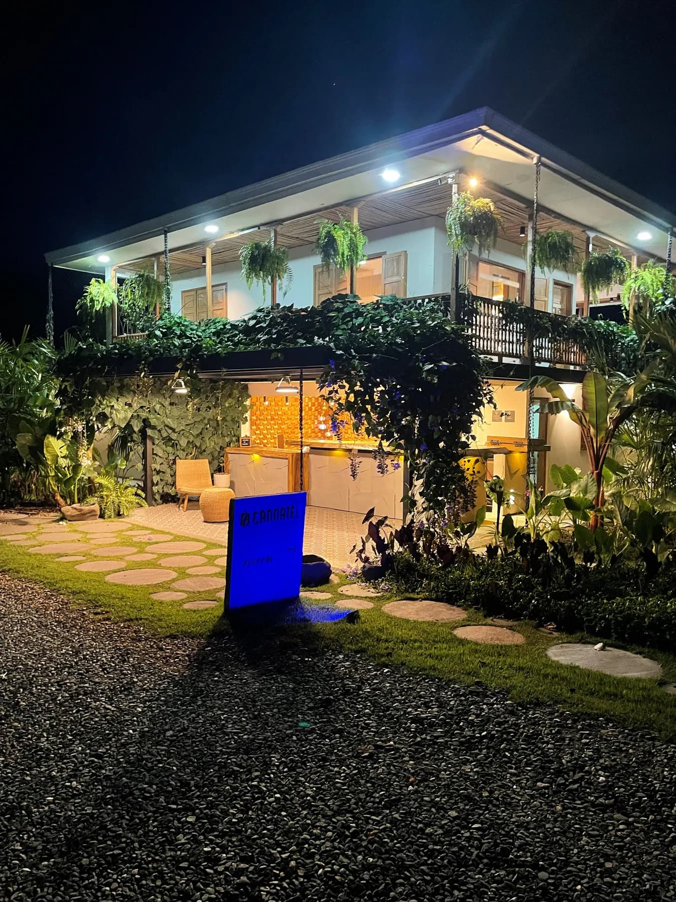 House lit at night with a screen set up in the garden